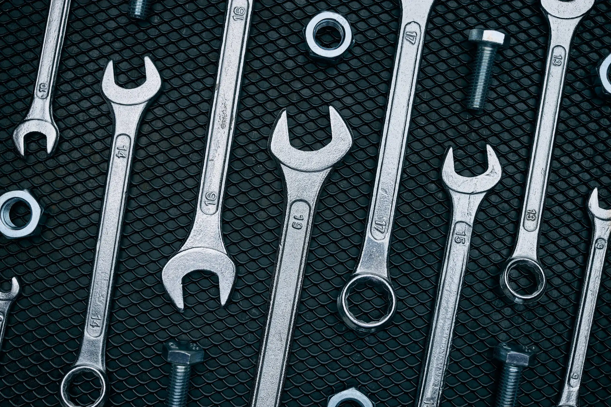 set of chrome wrenches on steel surface at service department