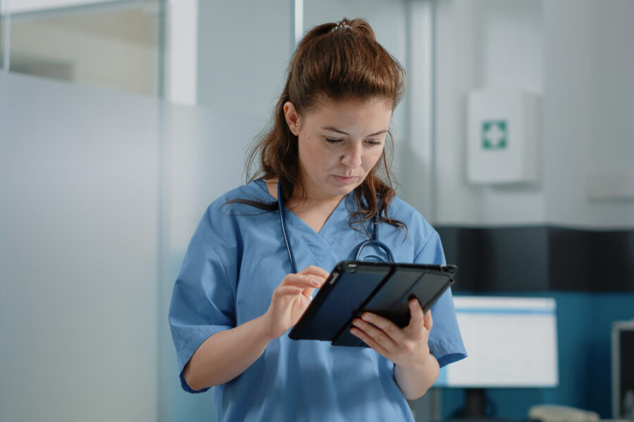 Caucasian nurse using digital tablet with touch screen