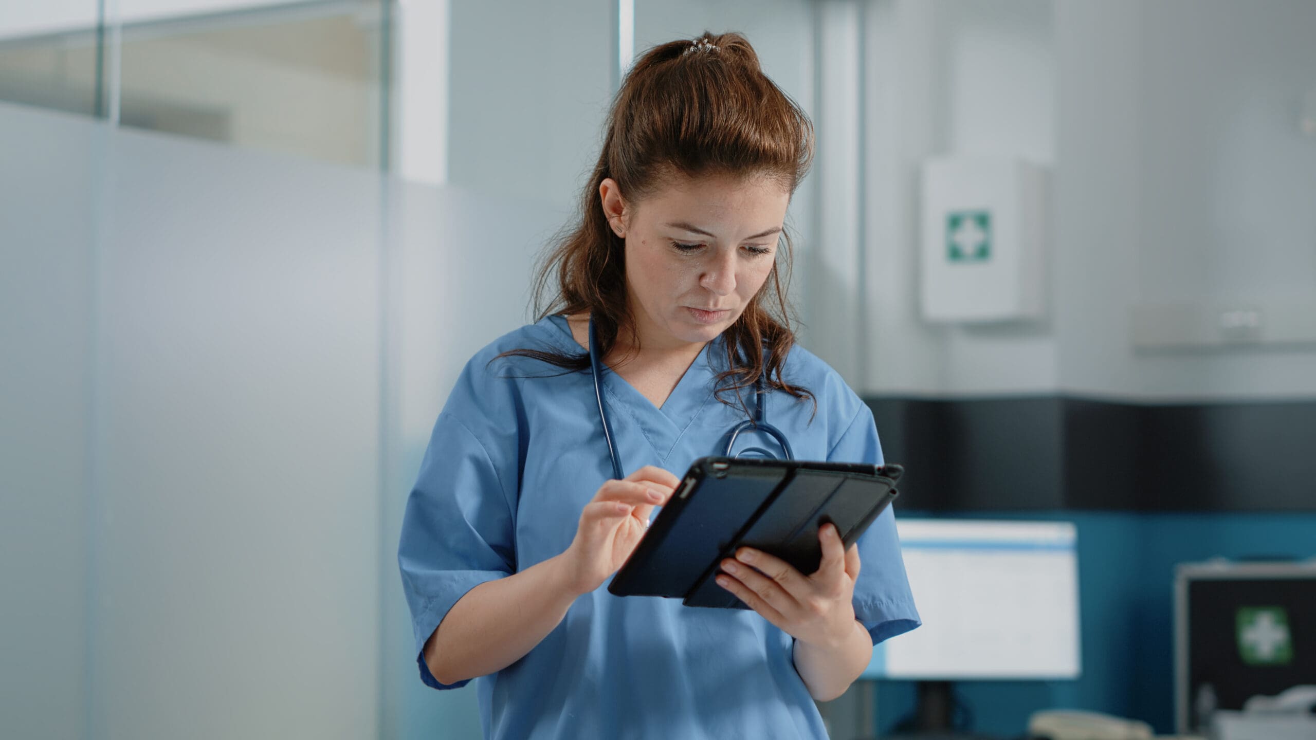 Caucasian nurse using digital tablet with touch screen