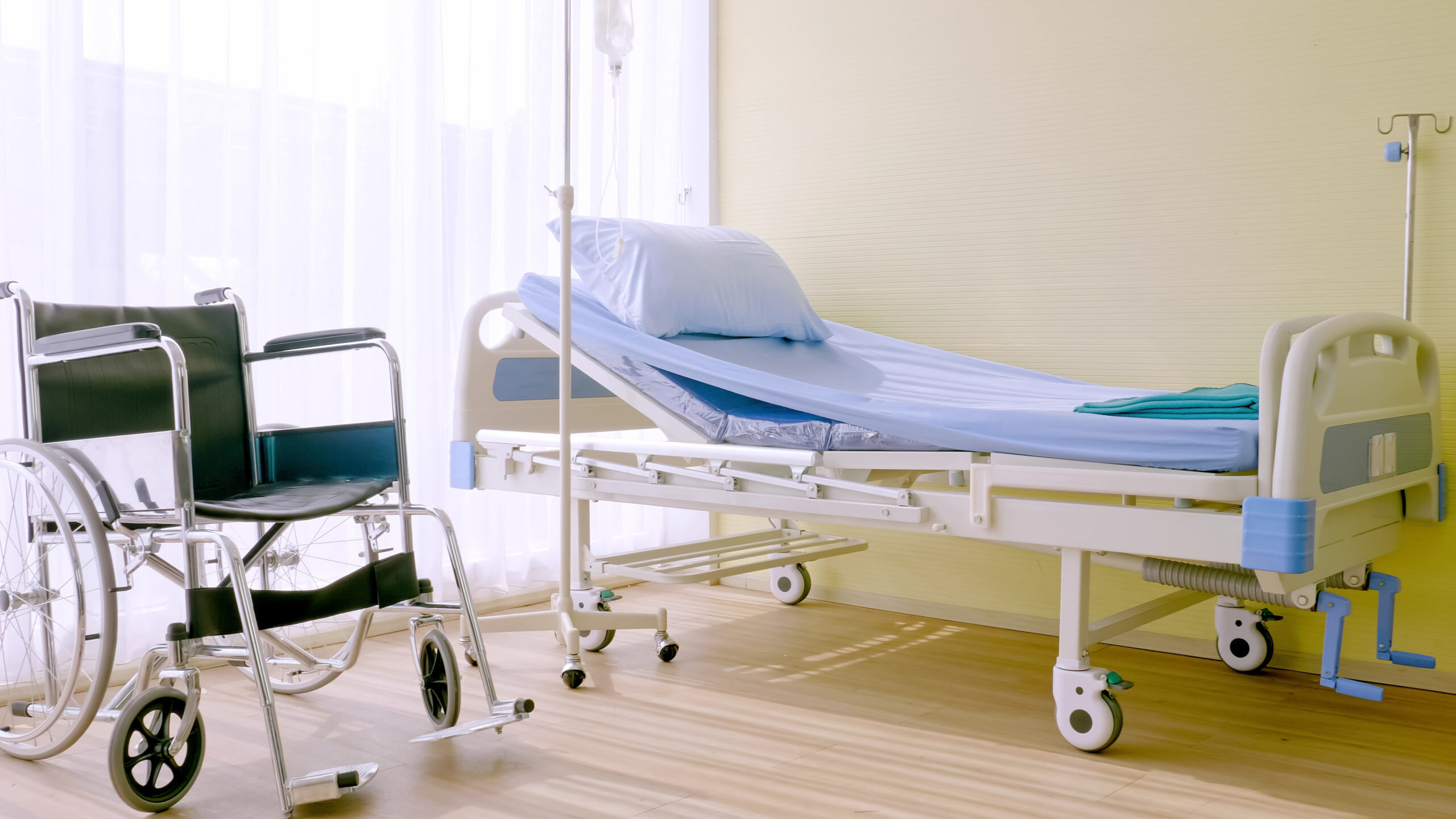 Hospital bed and wheelchair at hospital room.